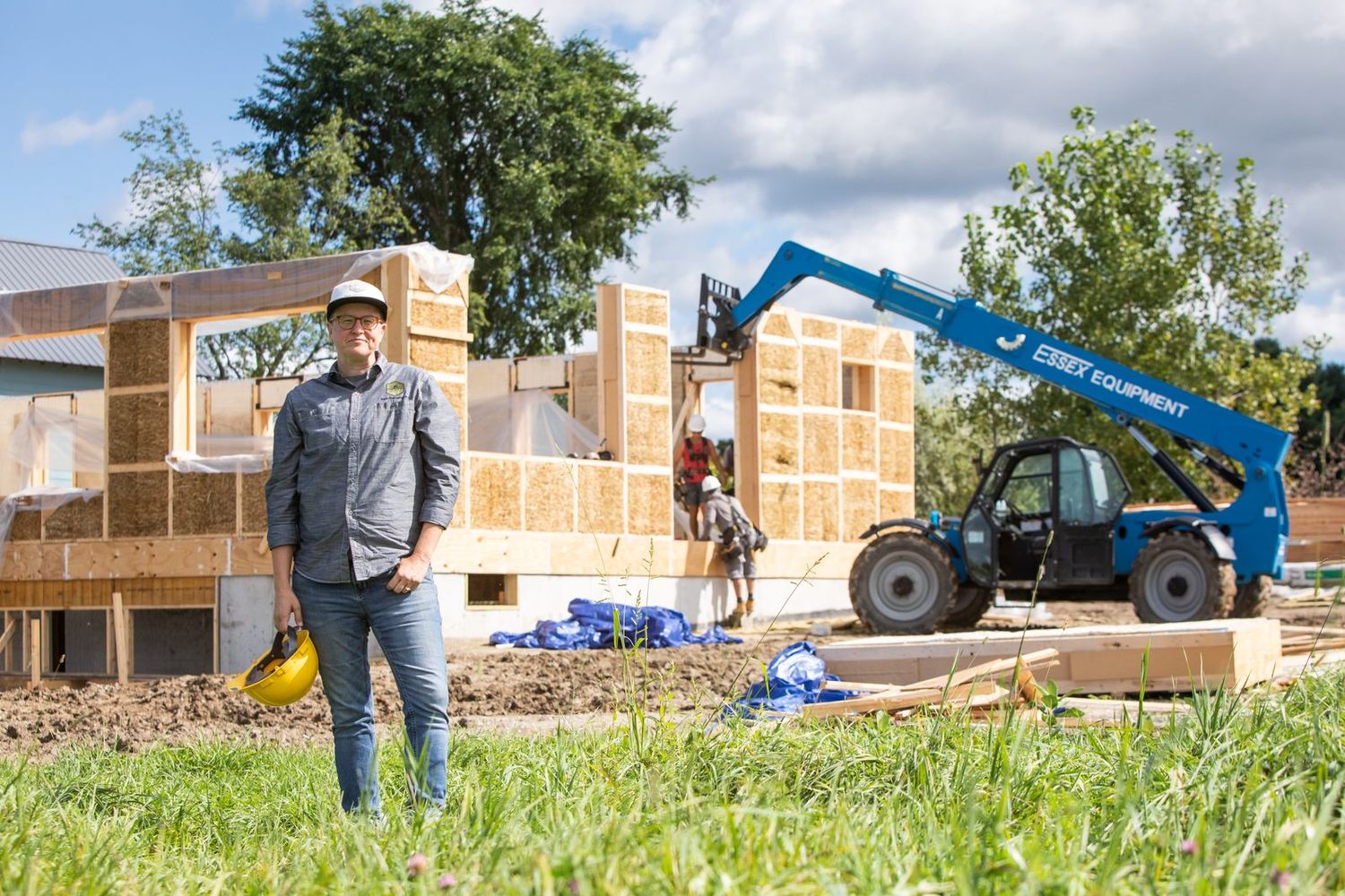 A crew raising straw panel walls on a rural site