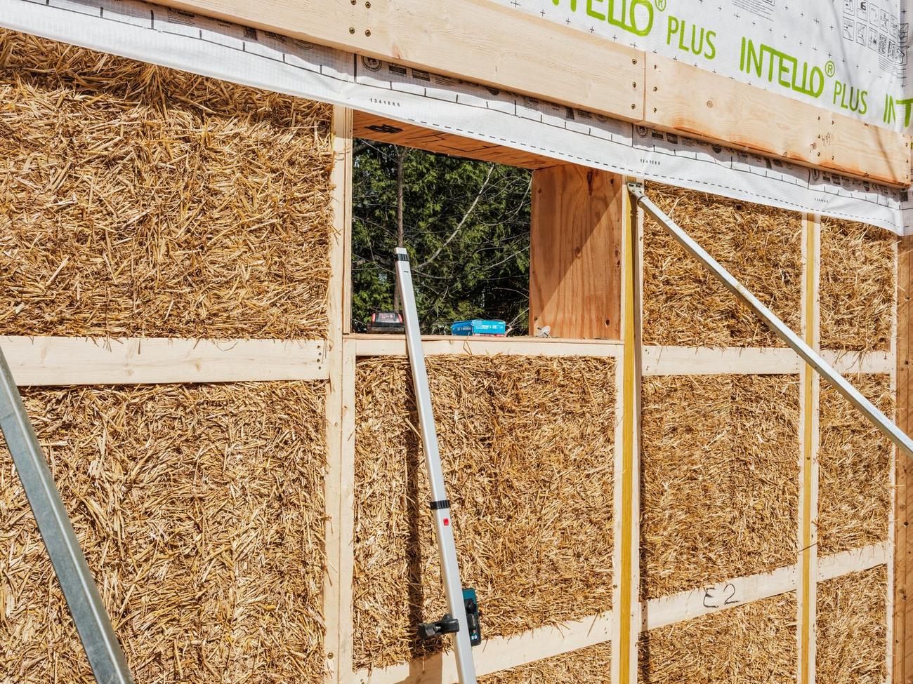 Straw panel walls standing on site beneath an airtight membrane